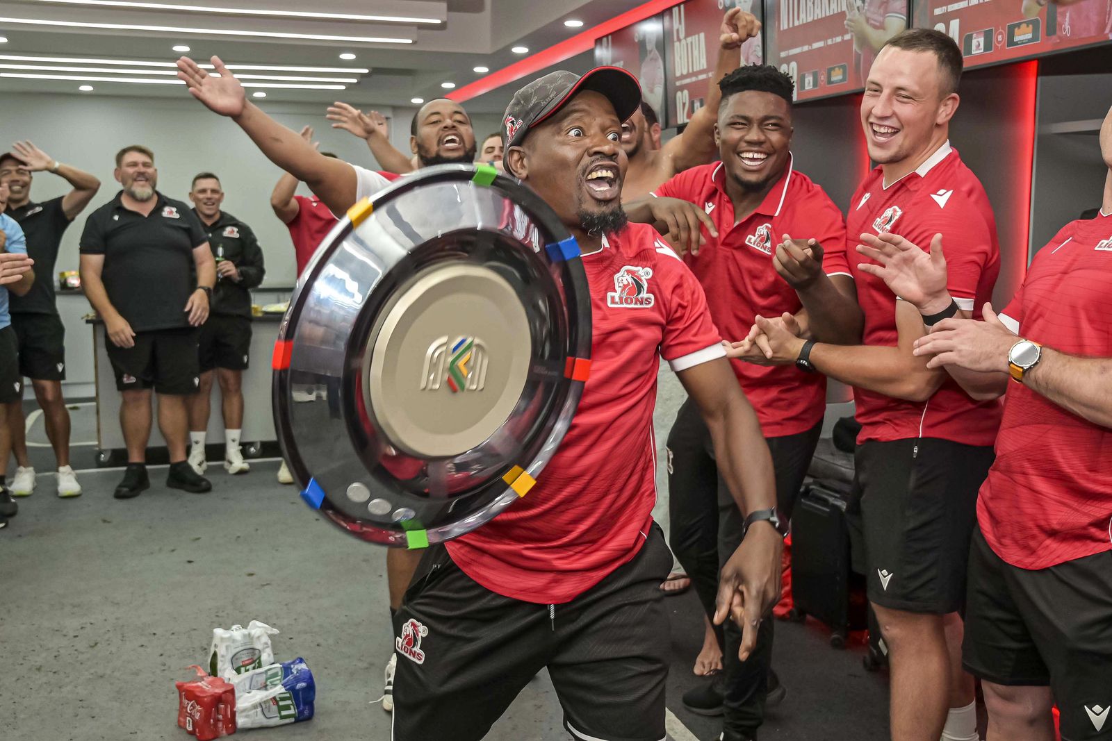 Johane Singwane celebrates with the South African Shield in the changing room after the match